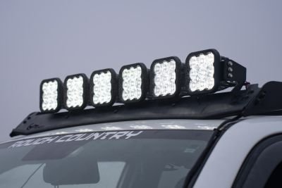 Roof-mounted fog lamp on a vehicle, positioned at the front for improved visibility in challenging weather conditions, shown in a queue of vehicles.